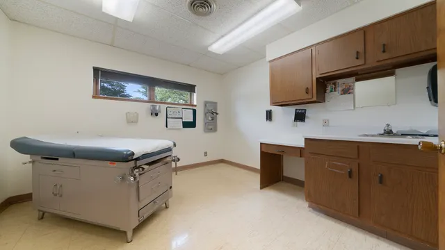 a utility room with stainless steel appliances kitchen island granite countertop a sink dishwasher a stove a microwave oven with a dining table and chairs