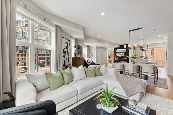 a living room with furniture dining area and a large window