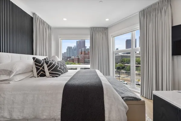 a bed sitting in a spacious bedroom next to a window