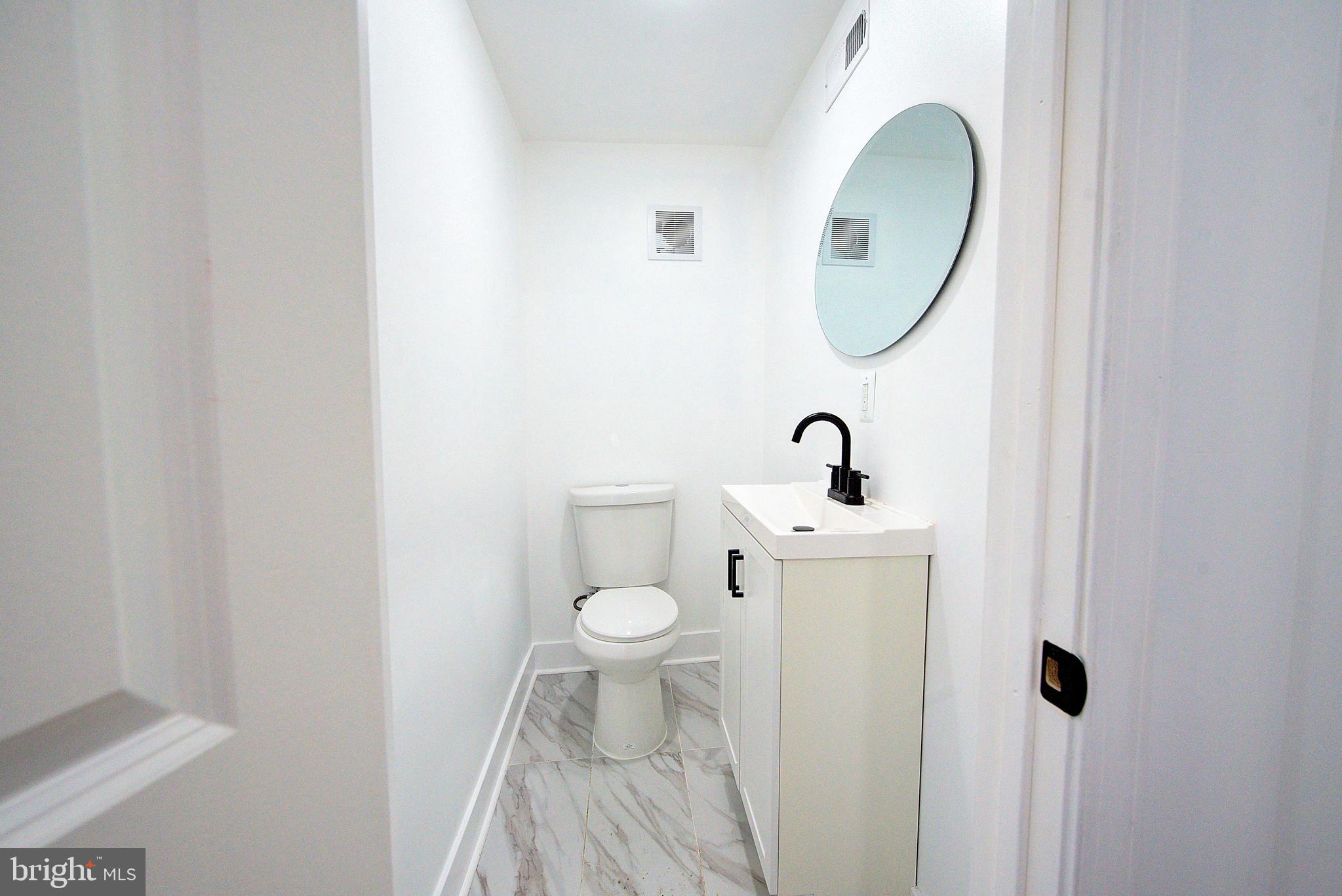 5736 Reedland Street Philadelphia, PA 19143 - Photo 9 of 22 a bathroom with a toilet a sink and mirror