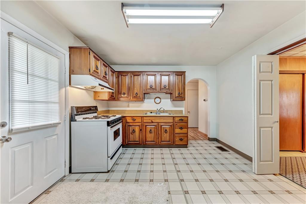 1299 Harvey Run Road Freedom, PA 15042 - Photo 4 of 25 a kitchen with a stove a sink and a refrigerator