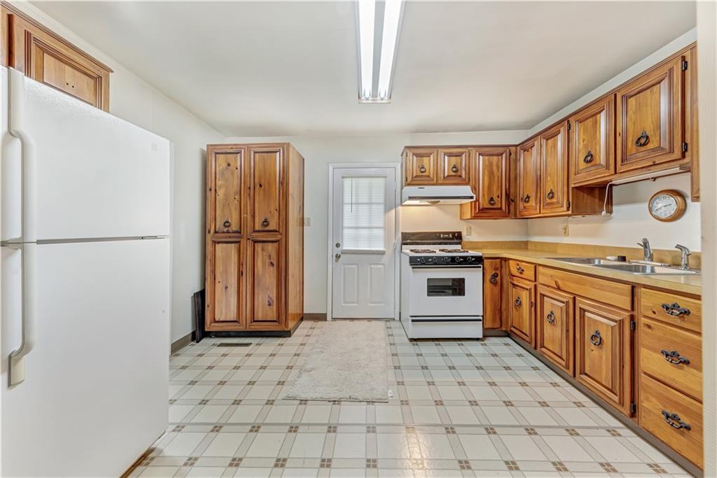 1299 Harvey Run Road Freedom, PA 15042 - Photo 7 of 25 a kitchen with stainless steel appliances a refrigerator sink and cabinets