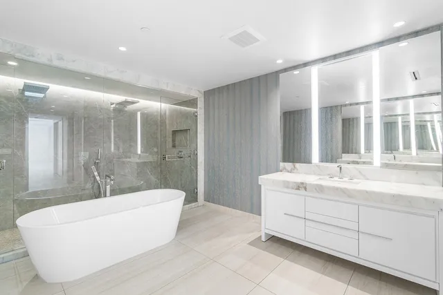 a spacious bathroom with a large tub shower and sink