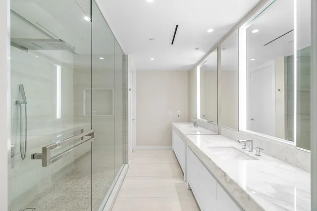 a bathroom with a granite countertop sink a mirror and a shower