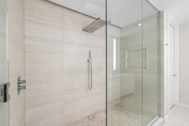 a bathroom with a shower and a glass door