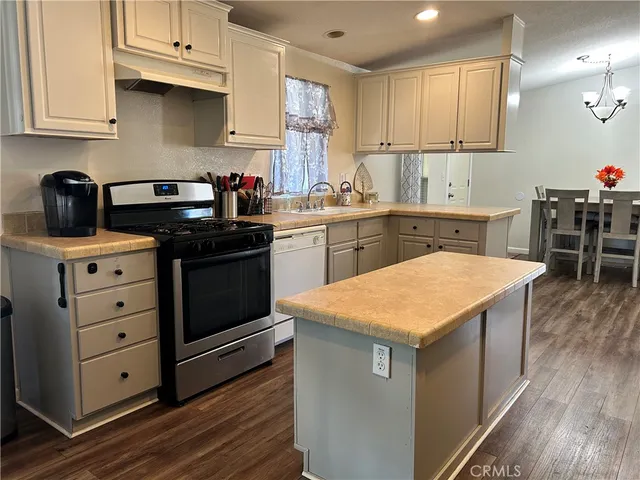 a kitchen with granite countertop a sink a stove and cabinets