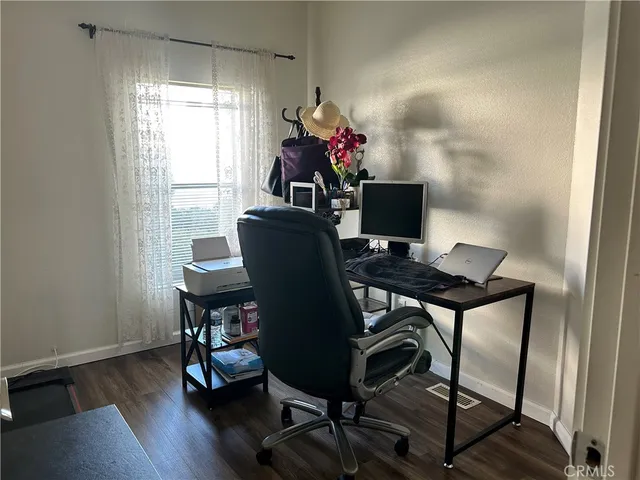a view of a workspace with furniture window and wooden floor