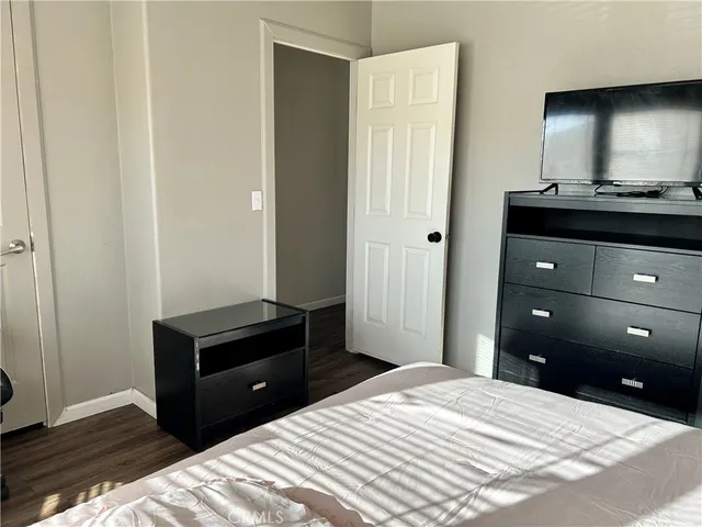 a bedroom with a bed and a mirror on dresser
