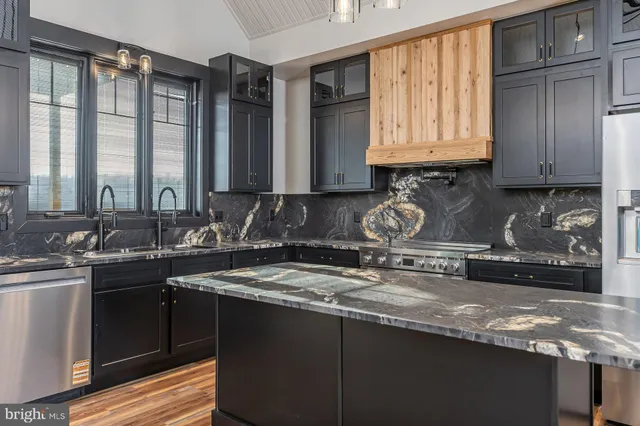 a kitchen with sink a stove and cabinets