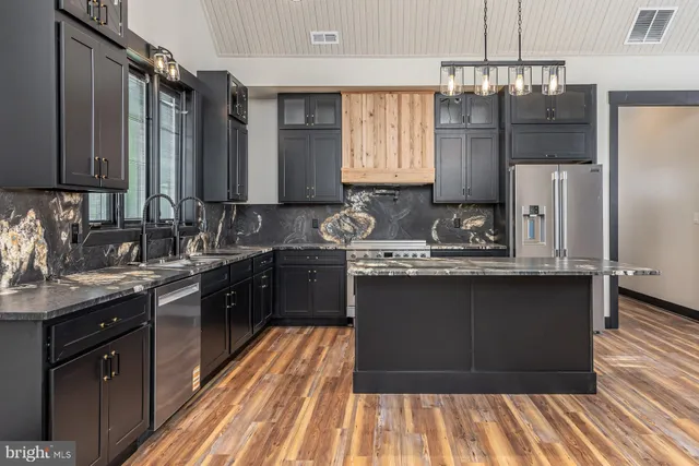a kitchen with granite countertop a sink stove and refrigerator