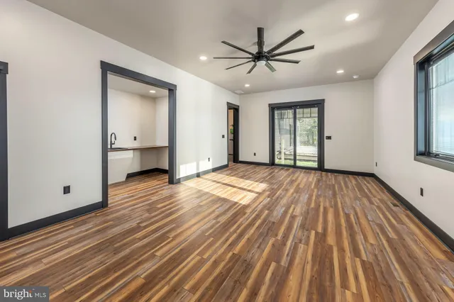 a view of empty room with wooden floor and window