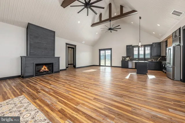 a view of empty room with wooden floor and fireplace