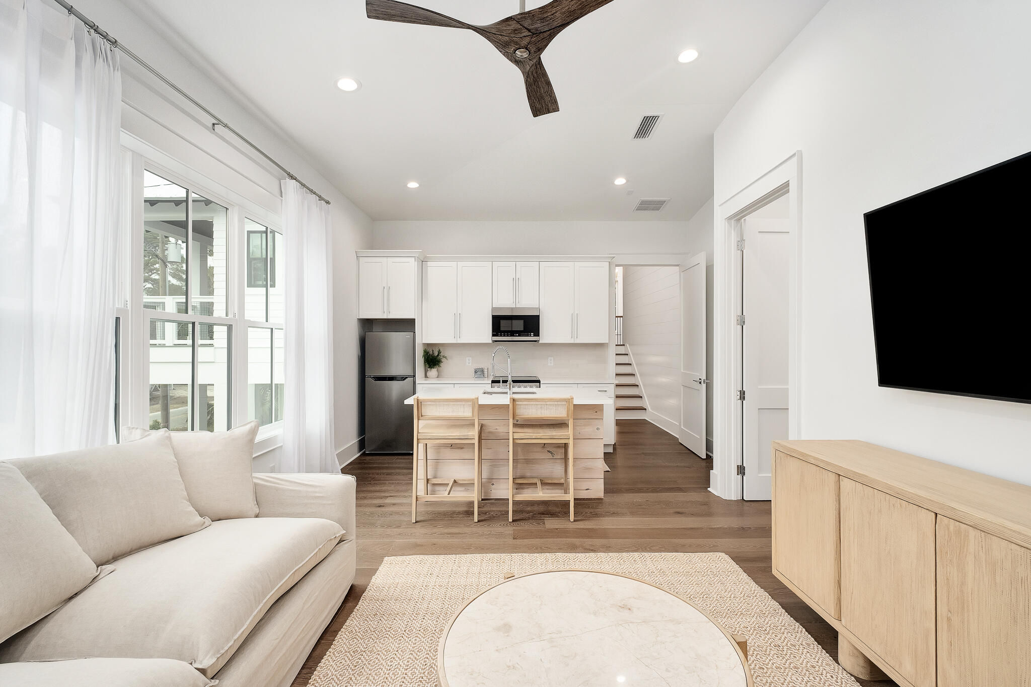 65 South Gulf Drive Santa Rosa Beach, FL 32459 - Photo 29 of 42 a living room with furniture a flat screen tv and kitchen view