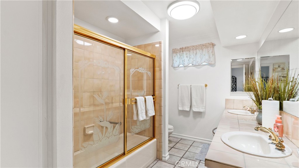 17850 Vista Del Lago Drive Riverside, CA 92503 - Photo 11 of 47 a bathroom with a sink a glass door shower and a mirror