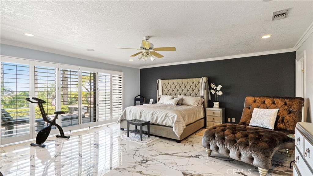 17850 Vista Del Lago Drive Riverside, CA 92503 - Photo 10 of 47 a spacious bedroom with two beds and a chandelier