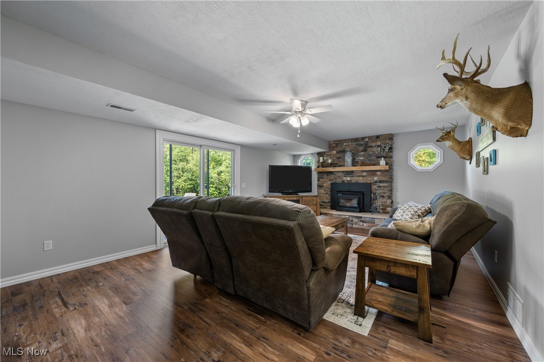 10229 Crawford Road Homerville, OH 44235 - Photo 14 of 42 Living area featuring a textured ceiling, dark wood-type flooring, and ceiling fan