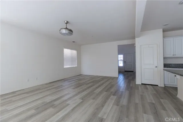 a view of empty room with wooden floor and window