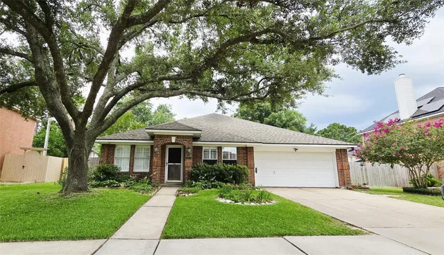 a front view of a house with a garden and trees