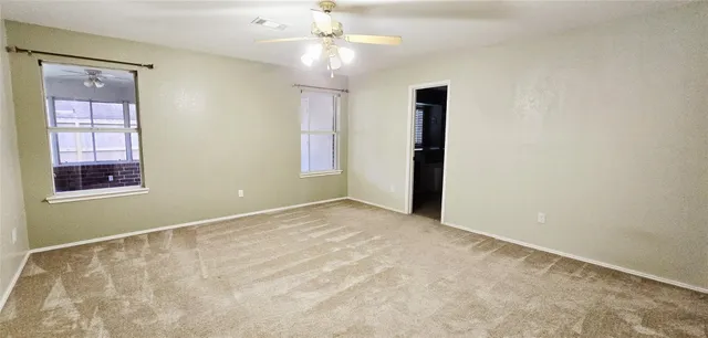 a view of an empty room with chandelier fan and fire place