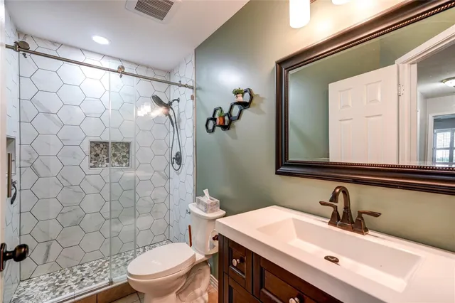 a bathroom with a sink vanity mirror and toilet