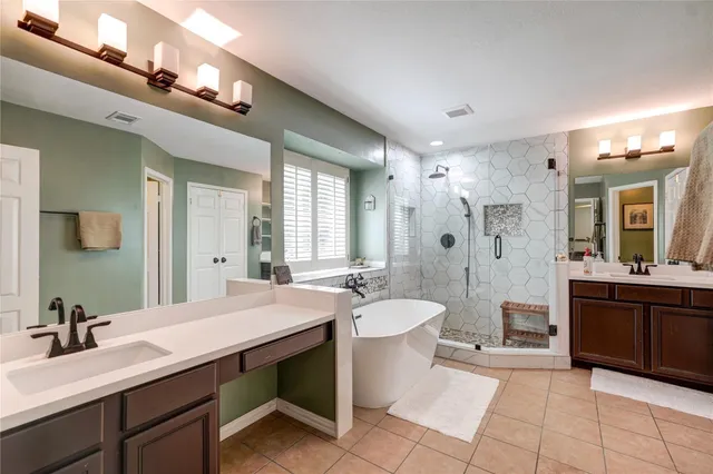 a spacious bathroom with a bathtub shower sink double and mirror