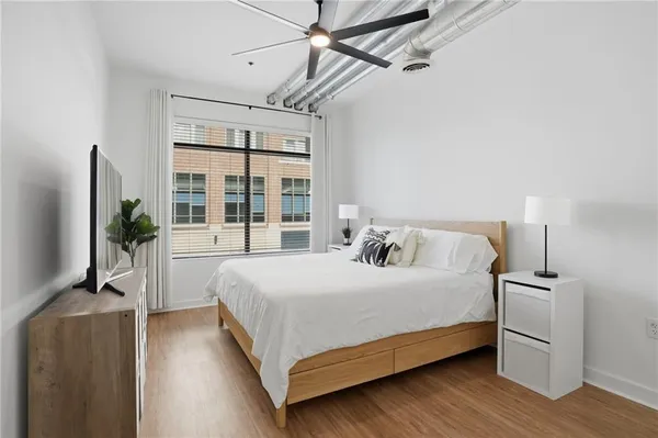 a bedroom with a large bed and a flat tv screen
