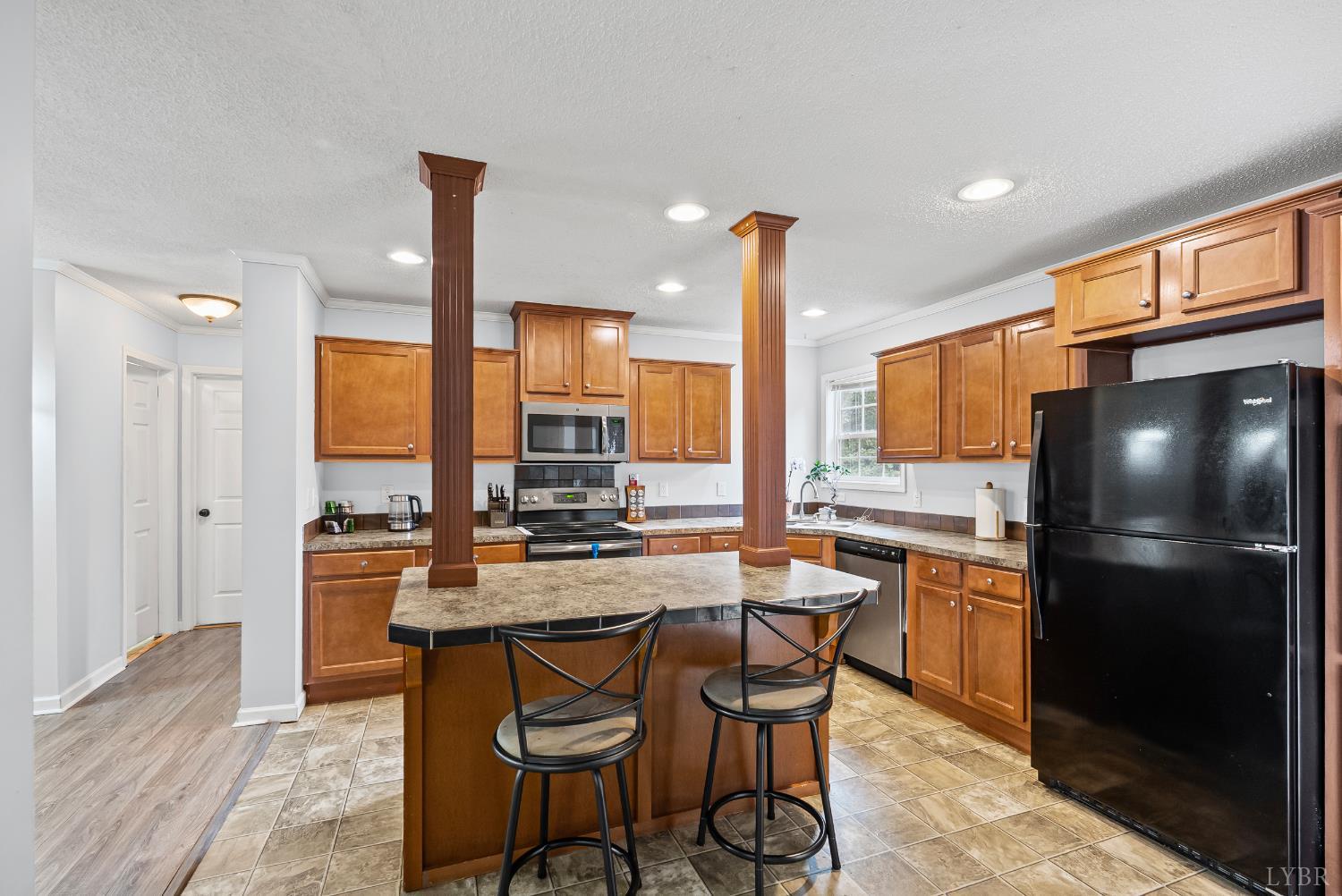 6124 Old Courthouse Road Appomattox, VA 24522 - Photo 11 of 52 a kitchen with stainless steel appliances granite countertop a stove a refrigerator a sink a dining table and chairs with wooden floor