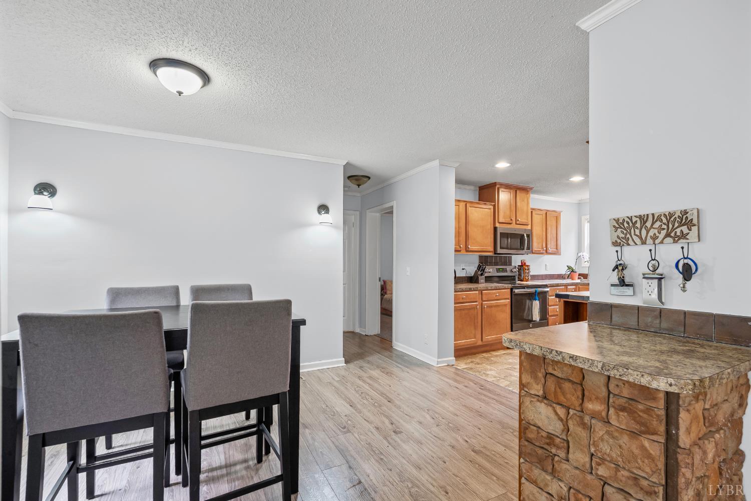 6124 Old Courthouse Road Appomattox, VA 24522 - Photo 18 of 52 a kitchen with stainless steel appliances granite countertop a table chairs and a refrigerator
