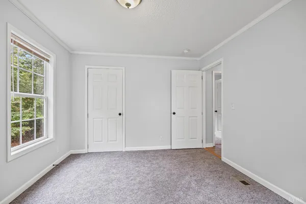 a view of house with wooden floor and large trees