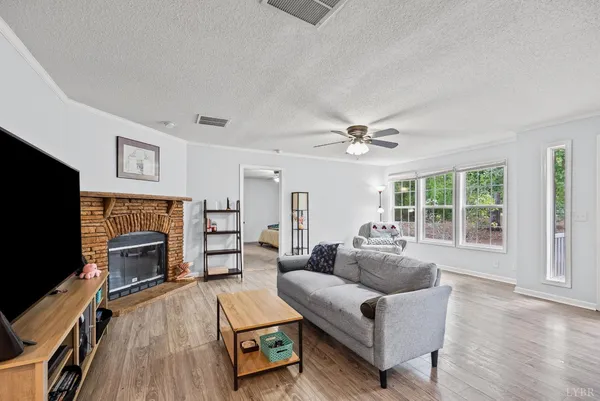a living room with furniture a flat screen tv and a fireplace
