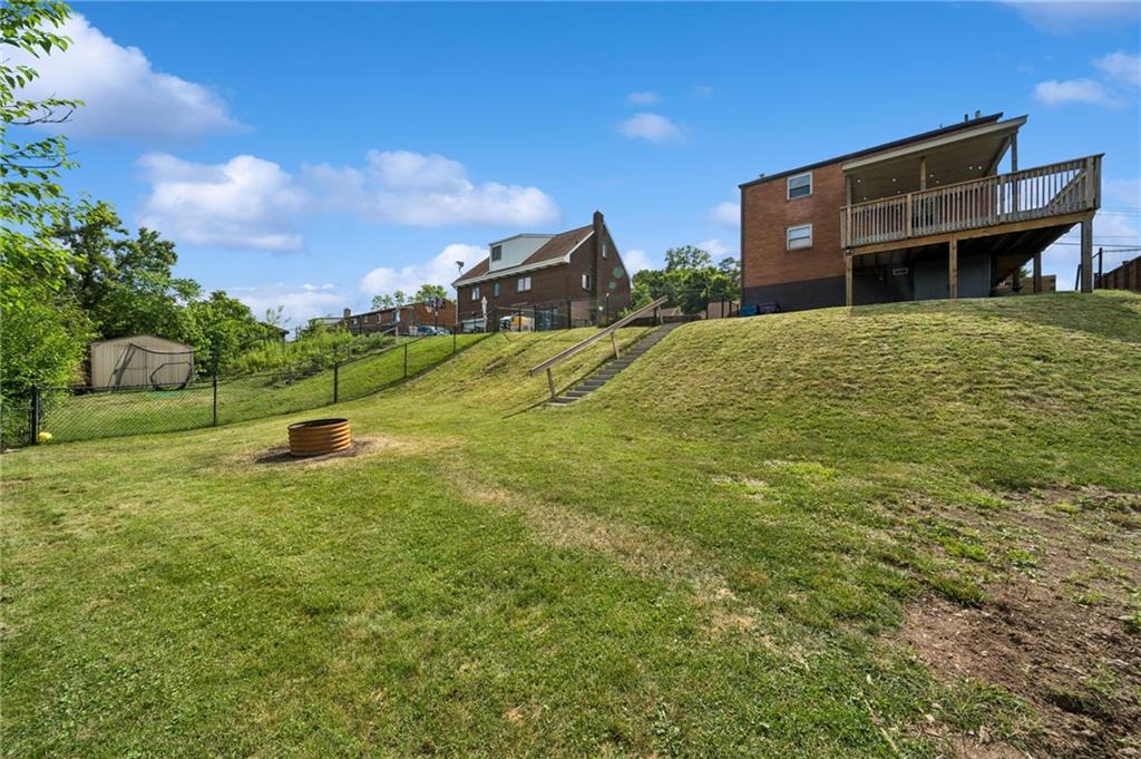 711 Jane Street Pittsburgh, PA 15239 - Photo 24 of 27 Spacious, fully fenced-in backyard showcasing a great fire pit area for outdoor entertainment.