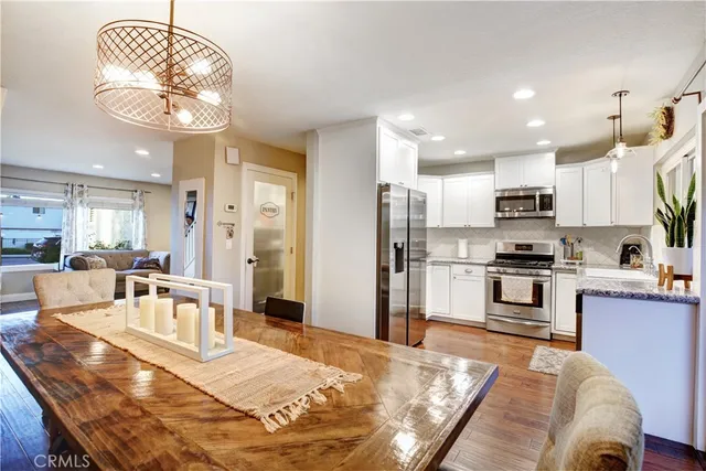 a large open kitchen with a refrigerator a stove top oven a sink and dining table