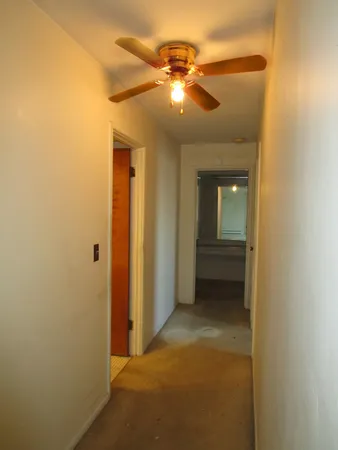 a view of a hallway with wooden shelves