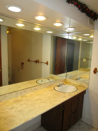 a bathroom with a granite countertop sink and a mirror