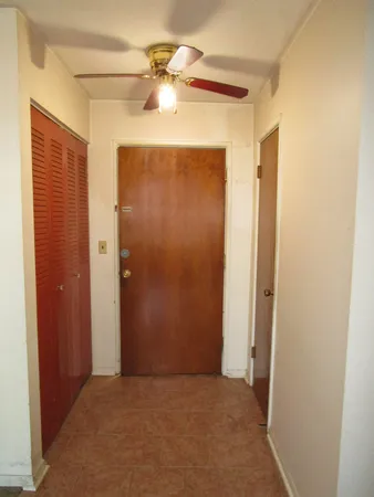 an empty room with windows and fan