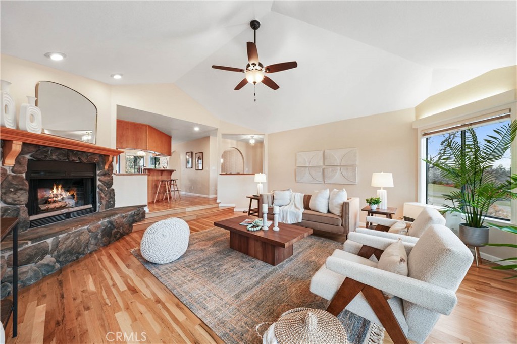 a living room with furniture a fireplace and a large window
