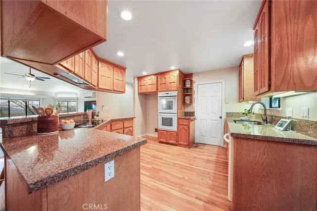a dinning room with kitchen island granite countertop wooden floor and stainless steel appliances