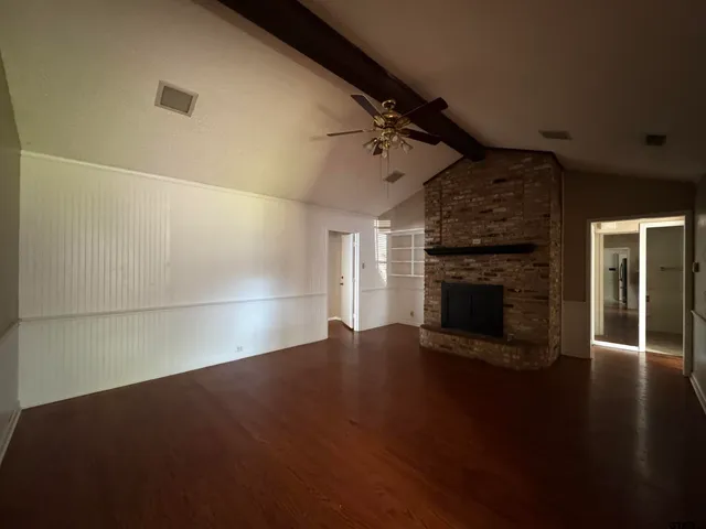 a view of empty room with wooden floor and fireplace