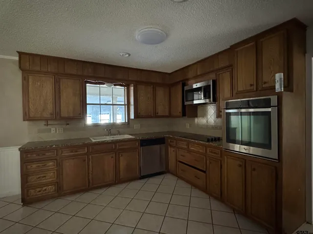 a kitchen with stainless steel appliances granite countertop a sink and stove top oven