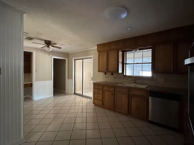 a large kitchen with granite countertop a stove a sink and a refrigerator