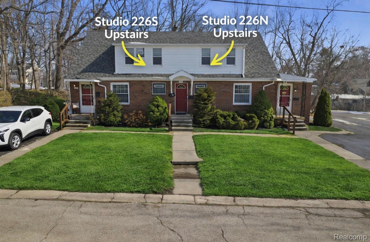 224 Chandler Street Romeo, MI 48065 - Photo 1 of 28 View of front of property with a front yard, brick siding, entry steps, and a shingled roof