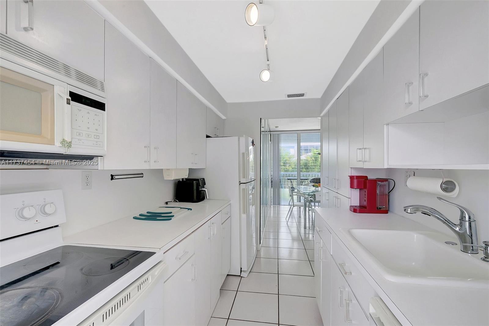 1155 103rd Street, Unit 9B Bay Harbor Islands, FL 33154 - Photo 17 of 43 a kitchen that has a sink and a stove top oven