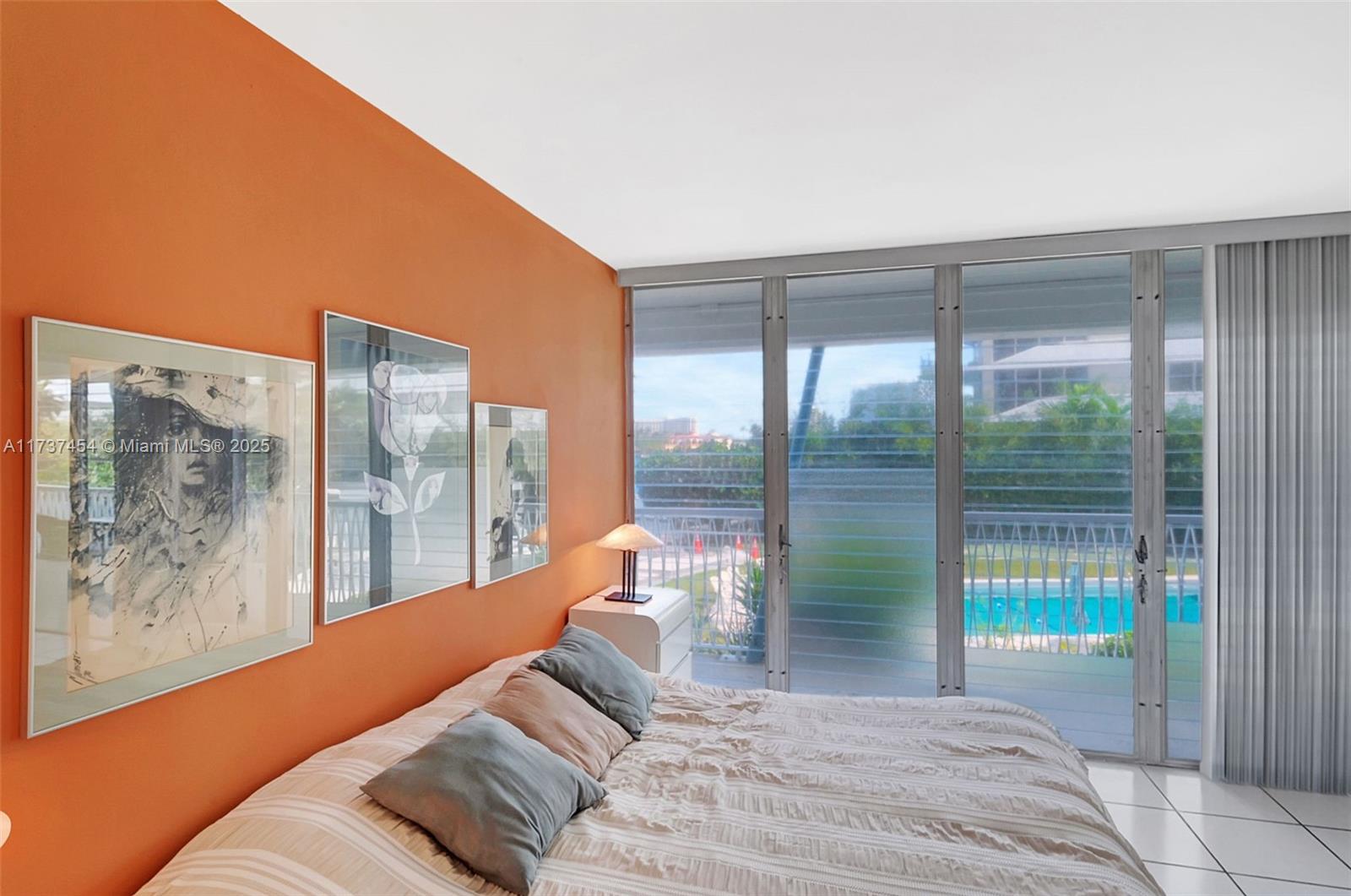 1155 103rd Street, Unit 9B Bay Harbor Islands, FL 33154 - Photo 21 of 43 a bedroom with a large bed and a large window with outer view