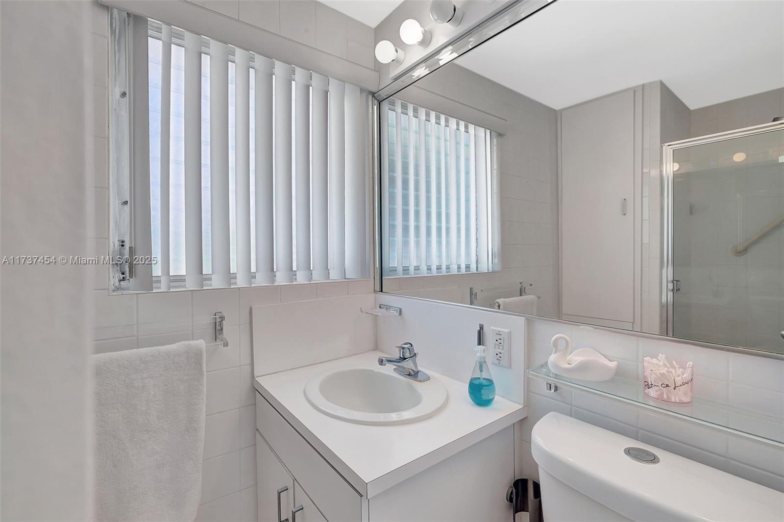1155 103rd Street, Unit 9B Bay Harbor Islands, FL 33154 - Photo 23 of 43 a bathroom with a sink and a toilet