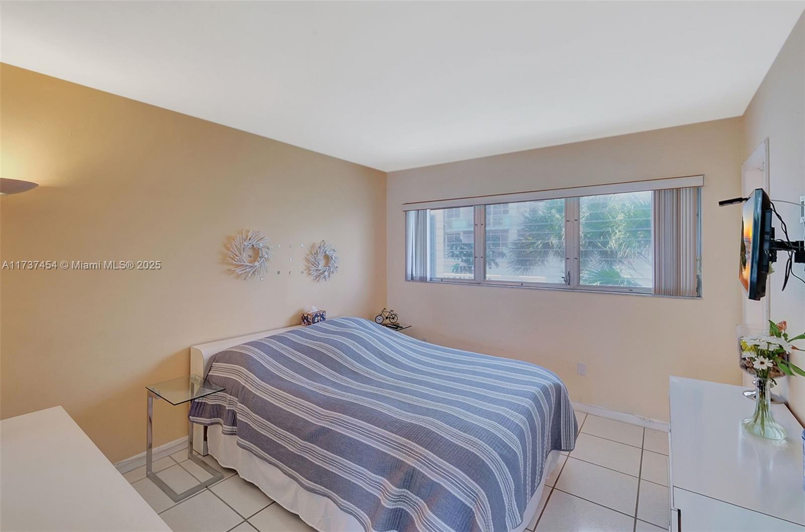 1155 103rd Street, Unit 9B Bay Harbor Islands, FL 33154 - Photo 24 of 43 a bedroom with a bed and a window