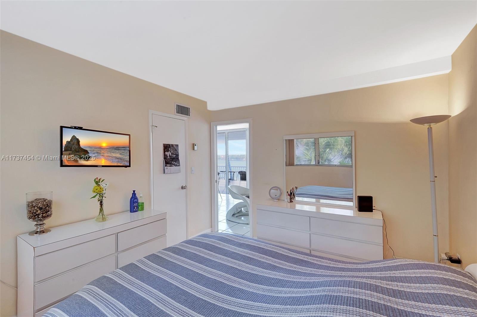1155 103rd Street, Unit 9B Bay Harbor Islands, FL 33154 - Photo 25 of 43 a room with a bed and a flat screen tv