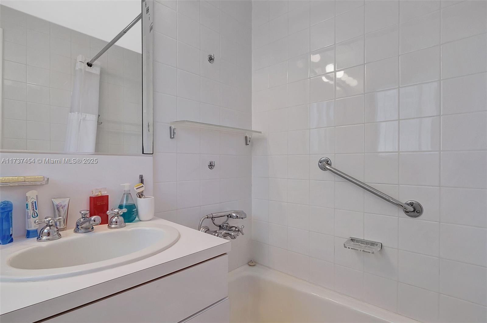 1155 103rd Street, Unit 9B Bay Harbor Islands, FL 33154 - Photo 27 of 43 a bathroom with a sink a toilet and shower