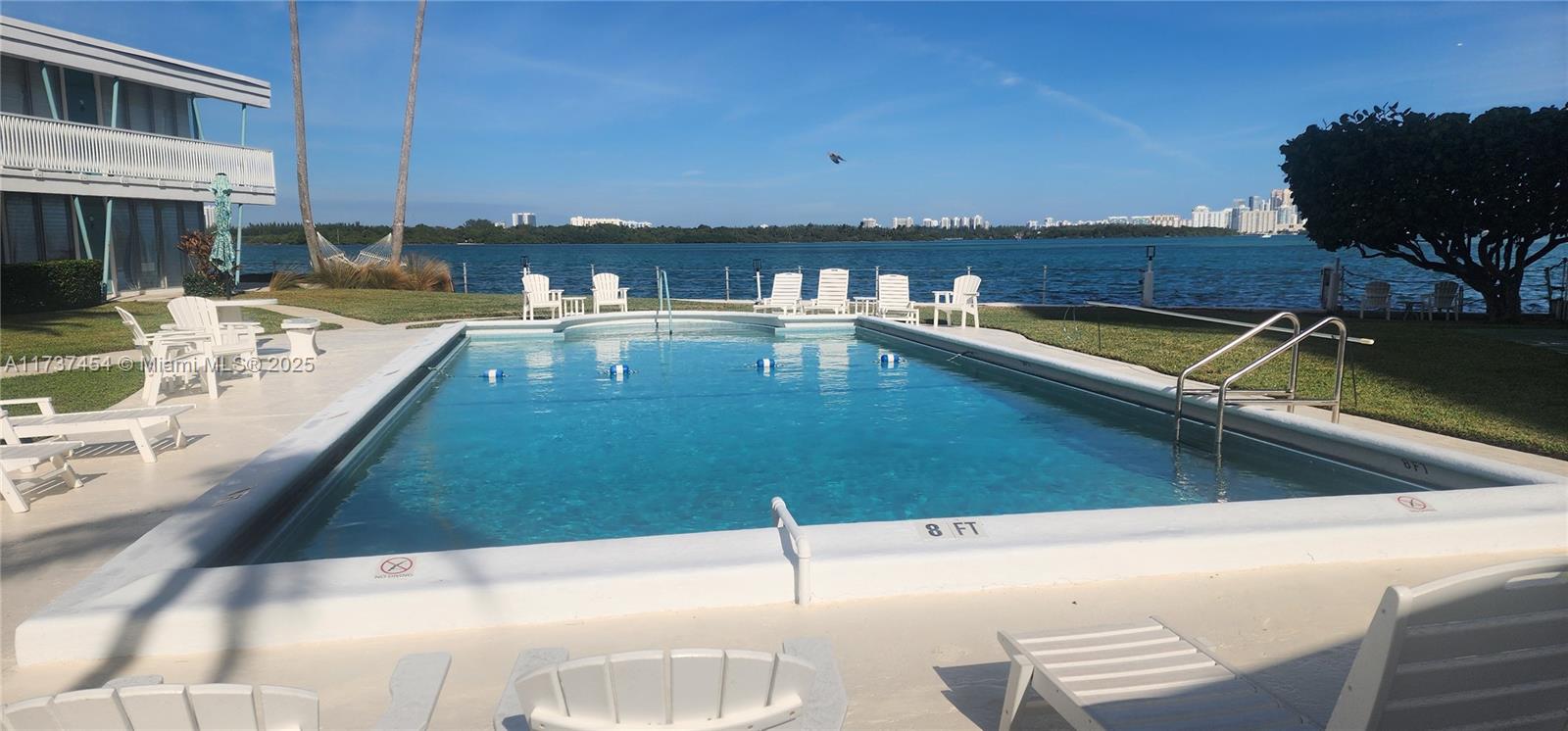 1155 103rd Street, Unit 9B Bay Harbor Islands, FL 33154 - Photo 5 of 43 a view of a swimming pool with lounge chairs