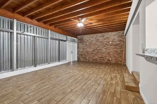 a view of an empty room with wooden floor