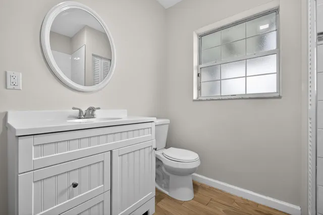 a bathroom with a toilet sink vanity and mirror